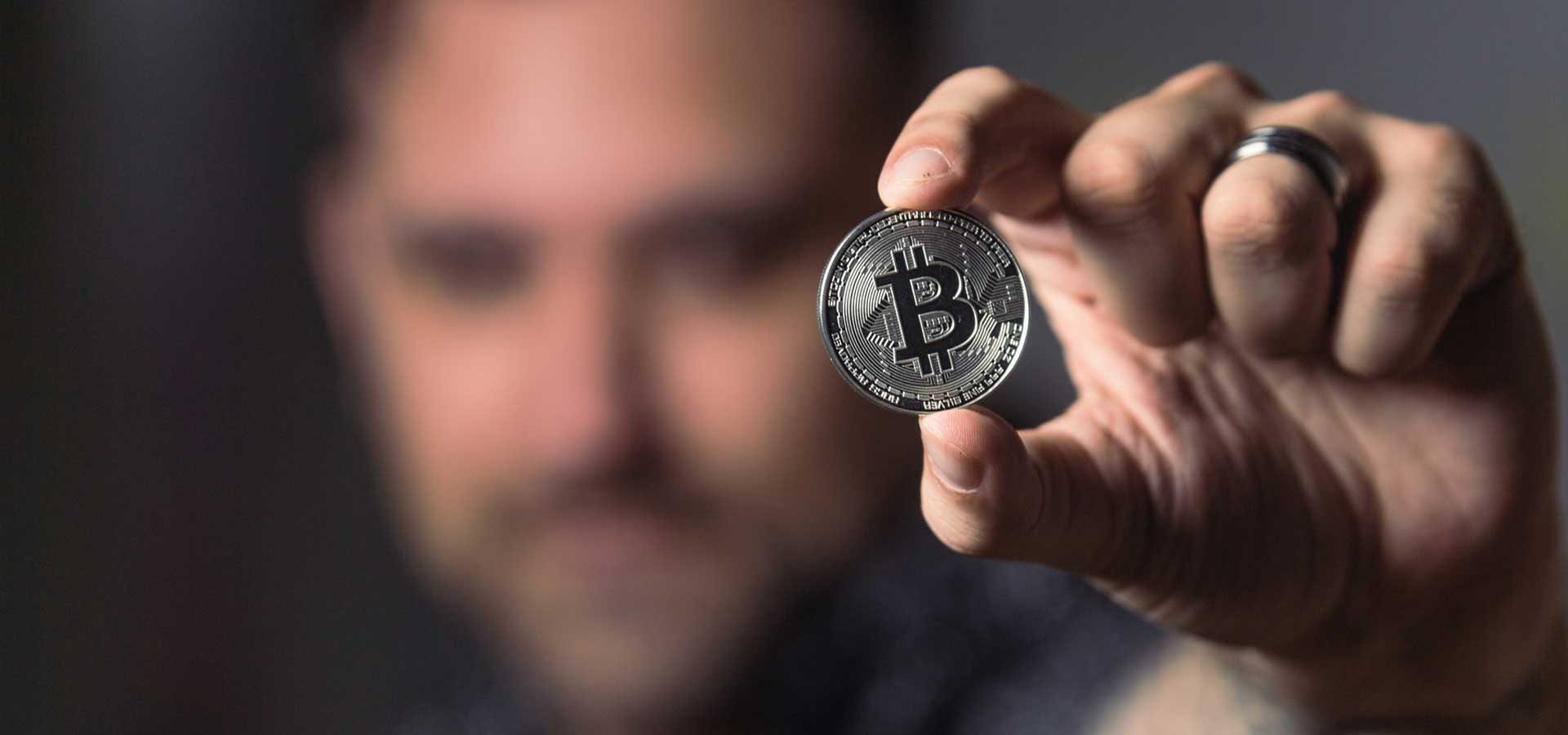 Mano sosteniendo moneda Bitcoin