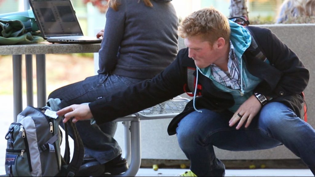 hombre sustrayendo algo de una mochila - percepcion de inseguridad